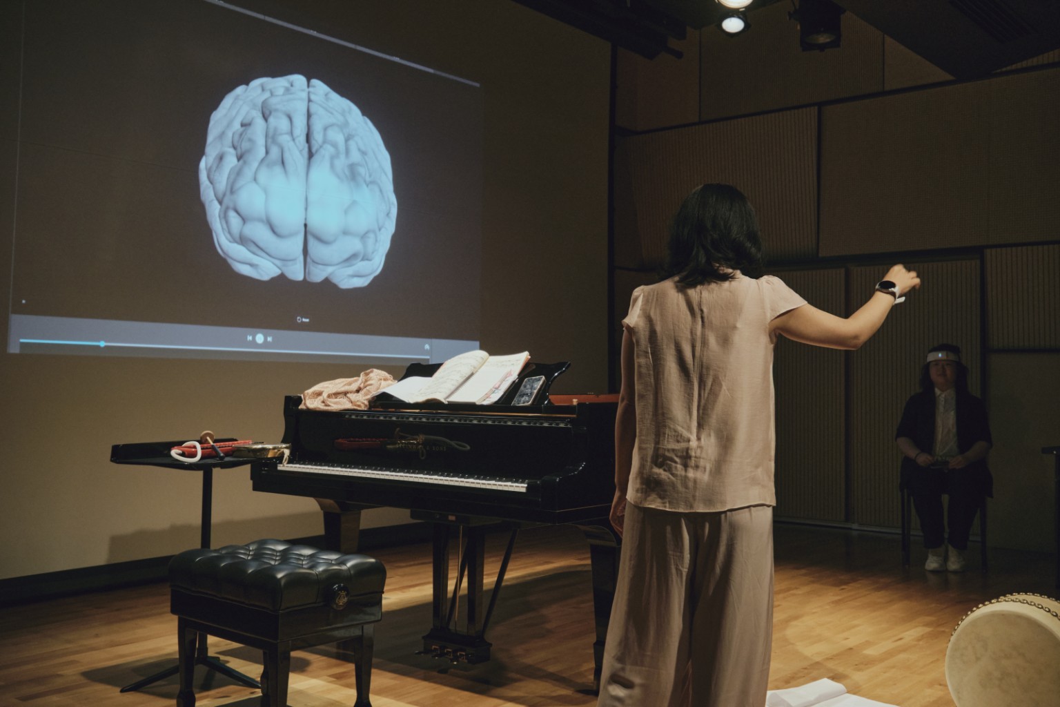 Performer with neural sensing device in front of projected generative imagery